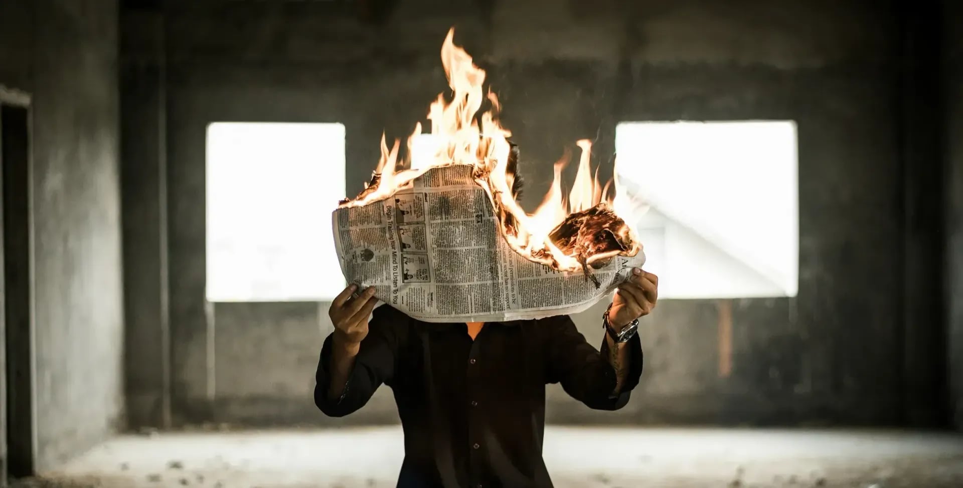 Photographie d'un homme tenant un journal qui brûle par Nijwam Swargiary